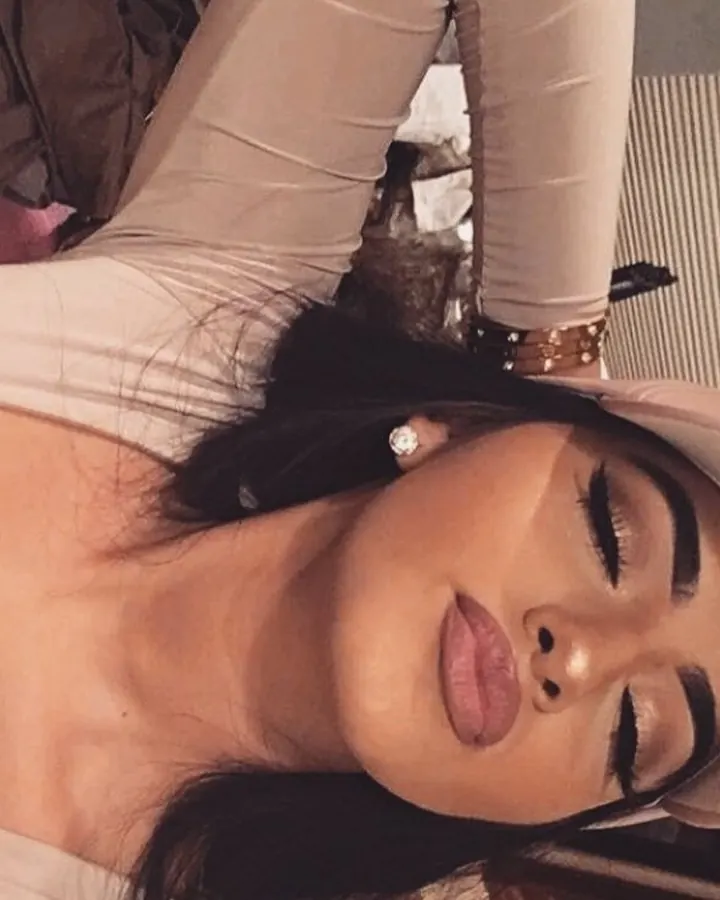Femme en tenue beige, allongée, regard sensuel